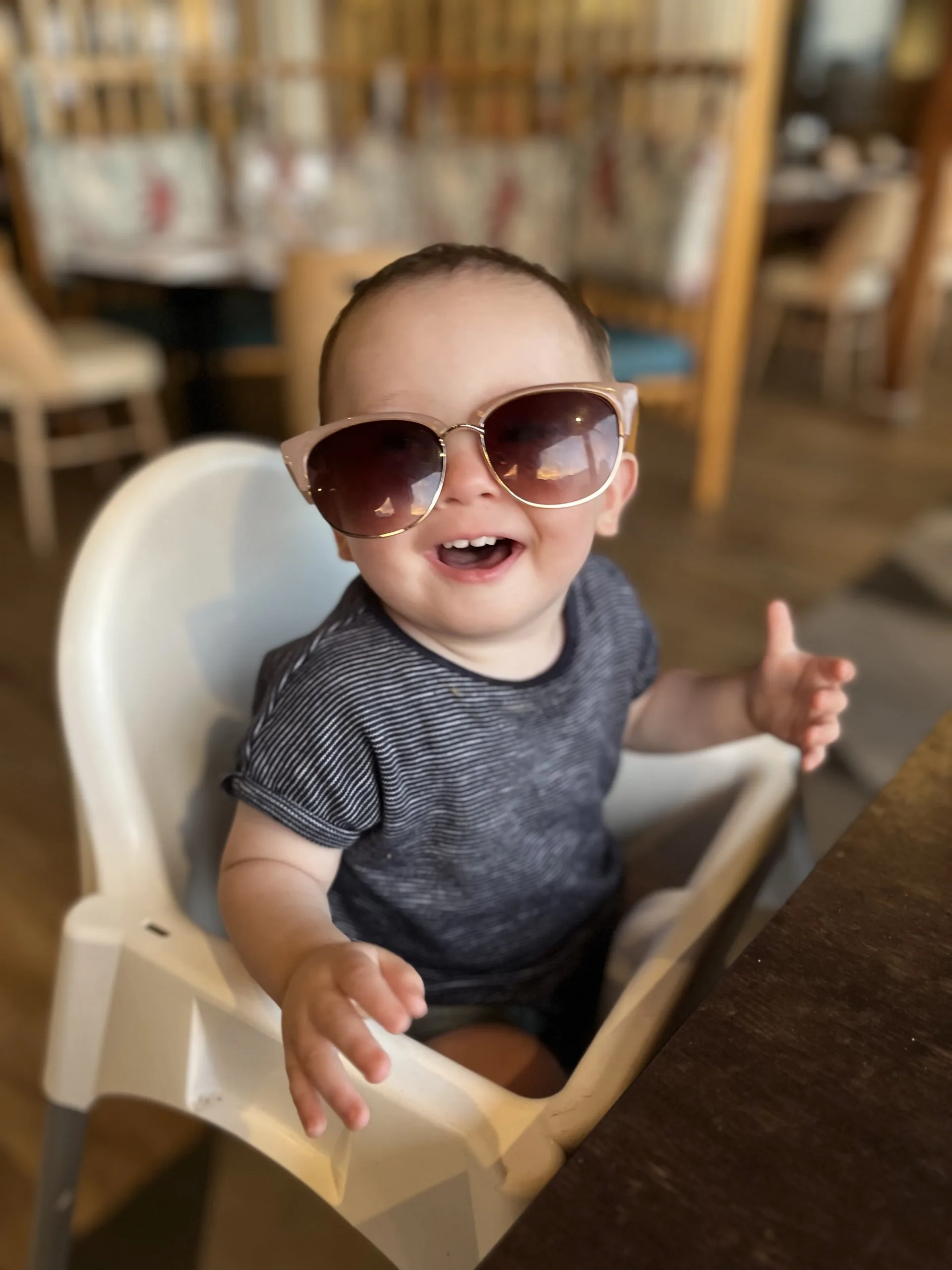 Lochie sat smiling in a high chair wearing sunglasses