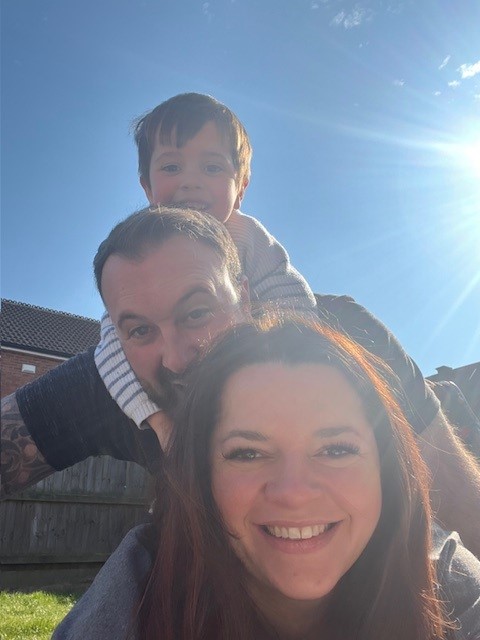 The Jackson Family at sunrise on top of Snowdon, holding a green CHSF banner