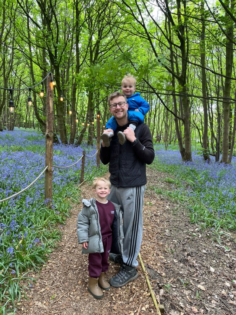 Roxy laying in a hospital bed smiling with her twin brother