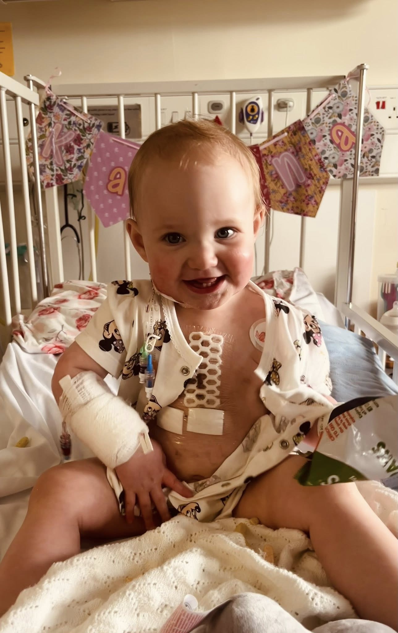 Matilda in hospital, asleep next to a pink rabbit