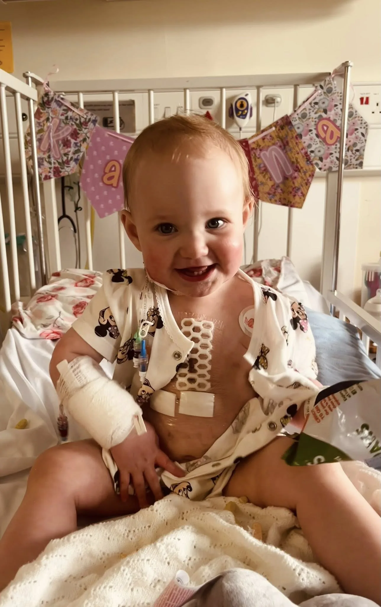 Matilda in hospital, asleep next to a pink rabbit