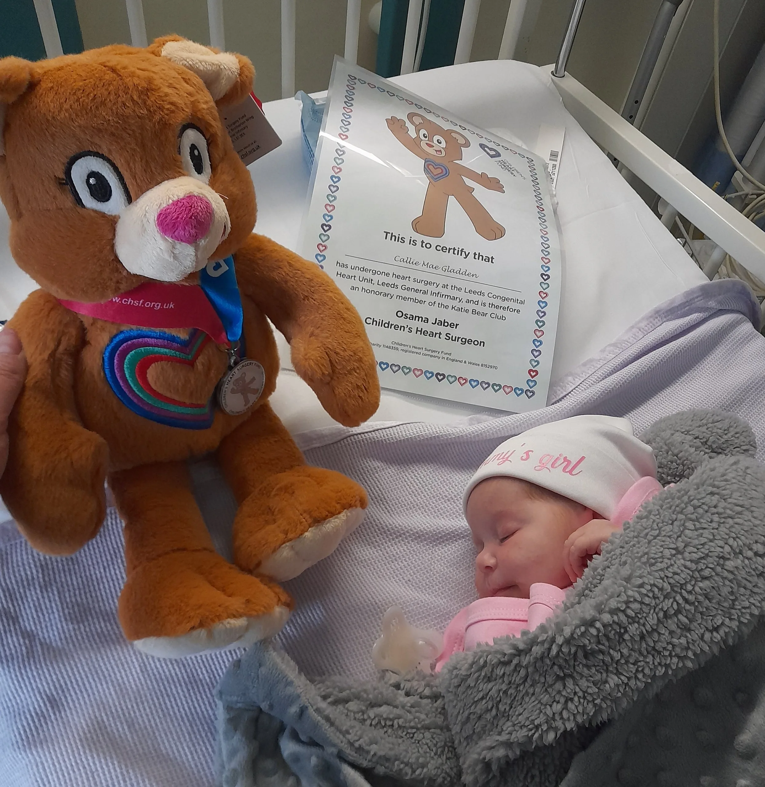 Small baby in hospital surrounding by lots of machines and tubes