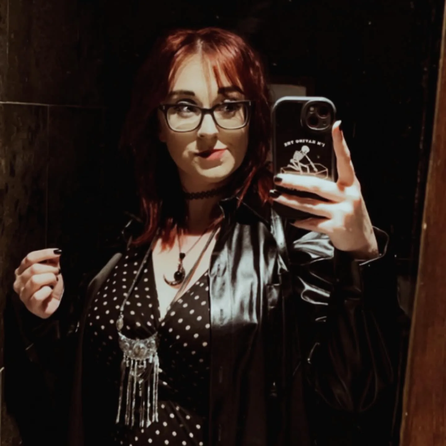 jessica wearing a white CHSF tshirt and gaming headphones, sat on th efloor of her bedroom holding a playstation controller. The image is a screengrab from a Facebook live