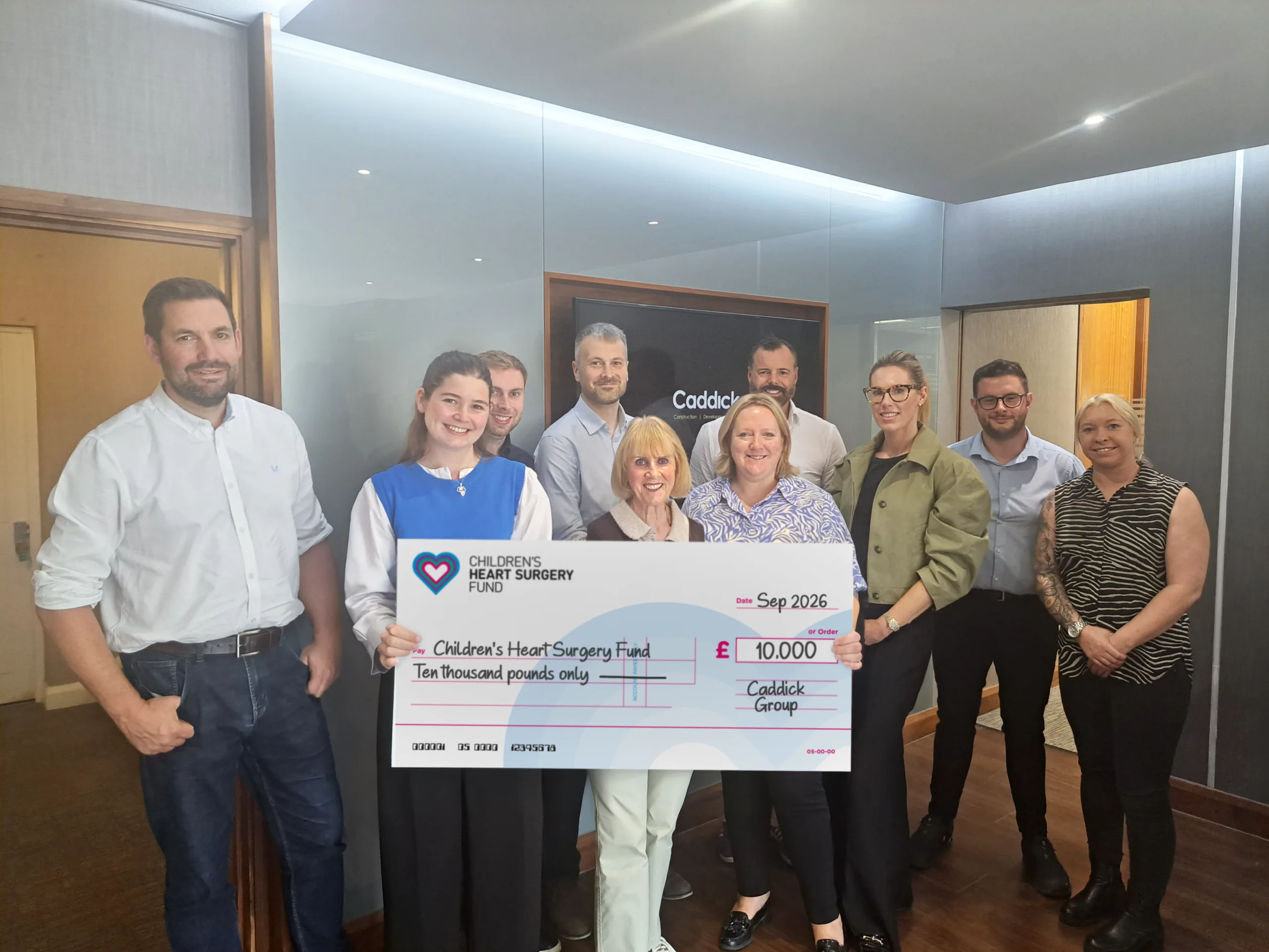 Group photo with large charity cheque. £10,000 to CHSF